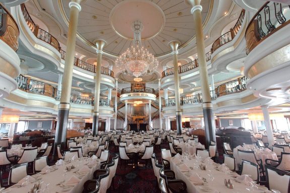 Elegant restaurant interior with intricate chandeliers and ornate decor.